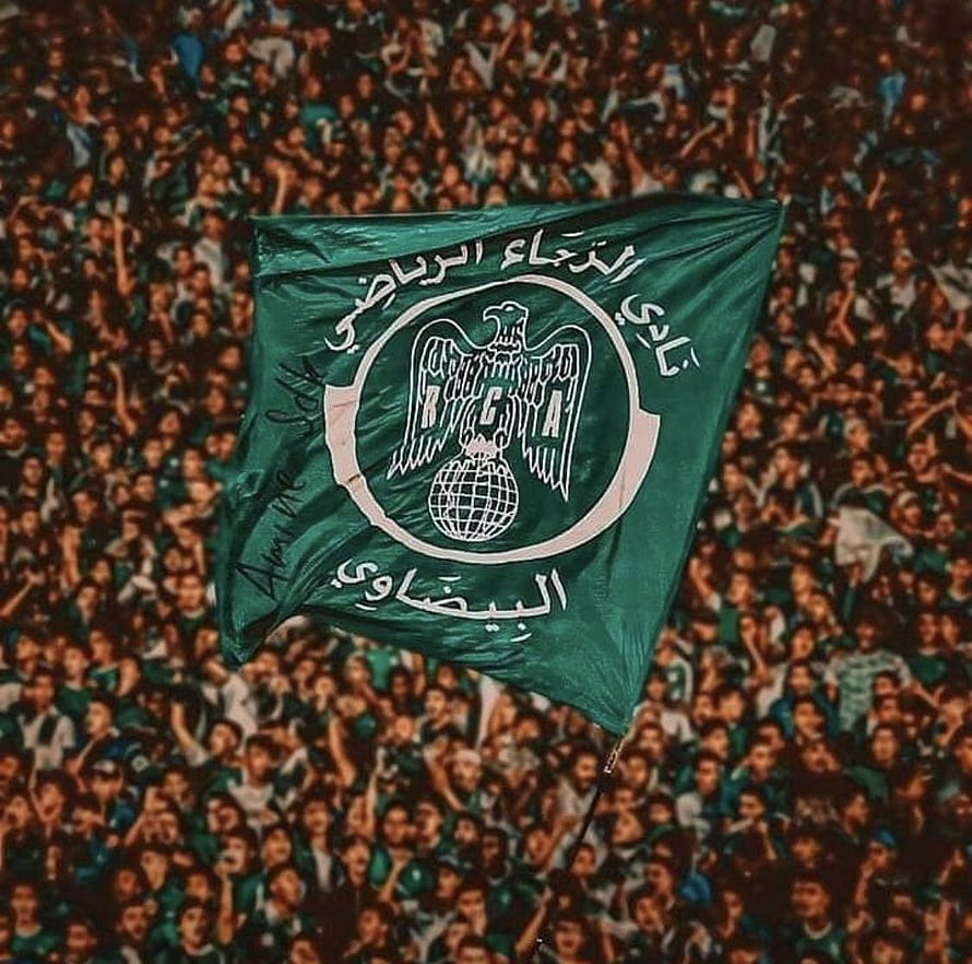 Raja Club Athletic Green Flag With Eagle Emblem Held Above a Dense Stadium Crowd HD wallpaper
