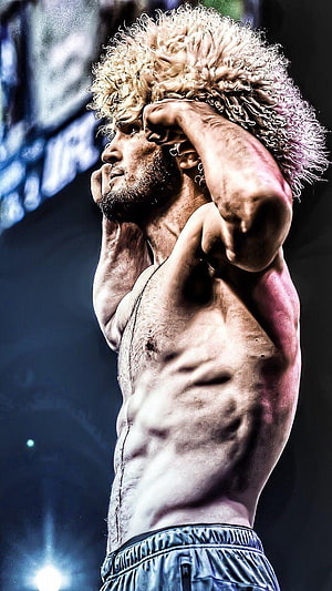 Khabib Nurmagomedov Intense Pre-Fight Portrait with Curly Blonde Hair and Defined Muscles HD phone wallpaper