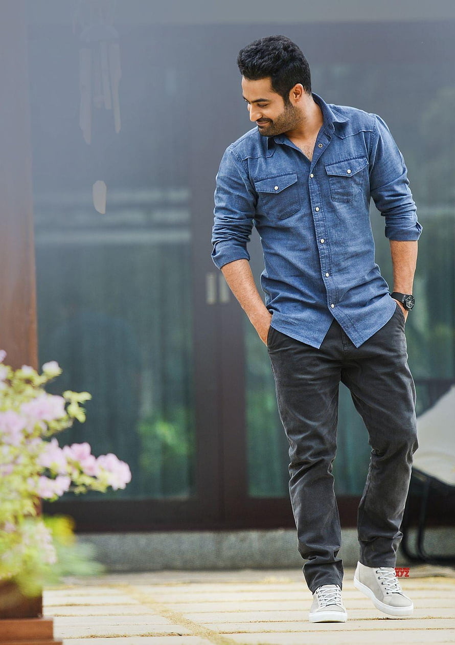 Actor Varun Dhawan in a casual blue denim shirt and dark jeans posing outdoors HD phone wallpaper