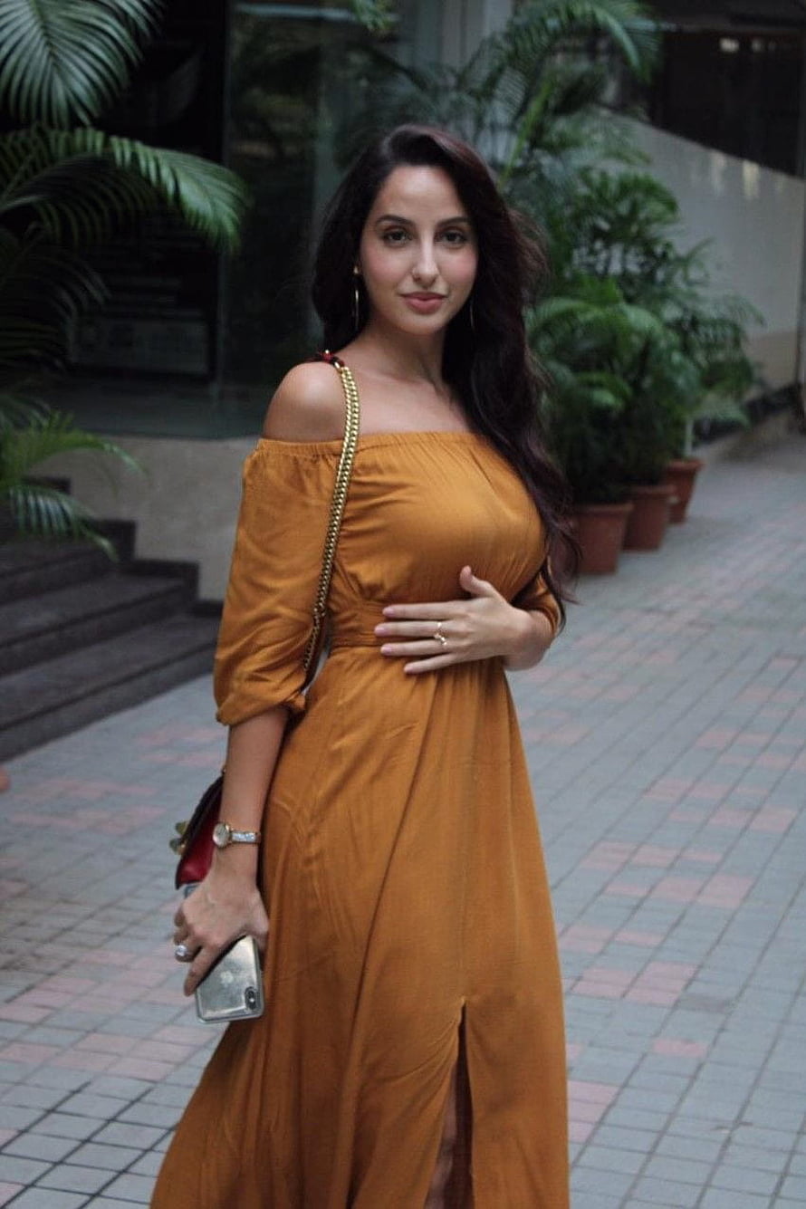Nora Fatehi in a mustard off-shoulder maxi dress with a gold chain strap bag HD phone wallpaper