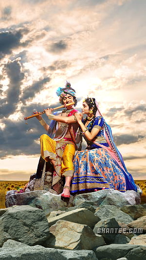 Radha Krishna Playing Flute on Rocky Outcrop Under Dramatic Sky HD phone wallpaper