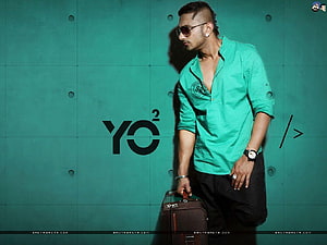 Yo Yo Honey Singh in Green Shirt and Sunglasses with Vintage Suitcase Against Teal Wall HD wallpaper