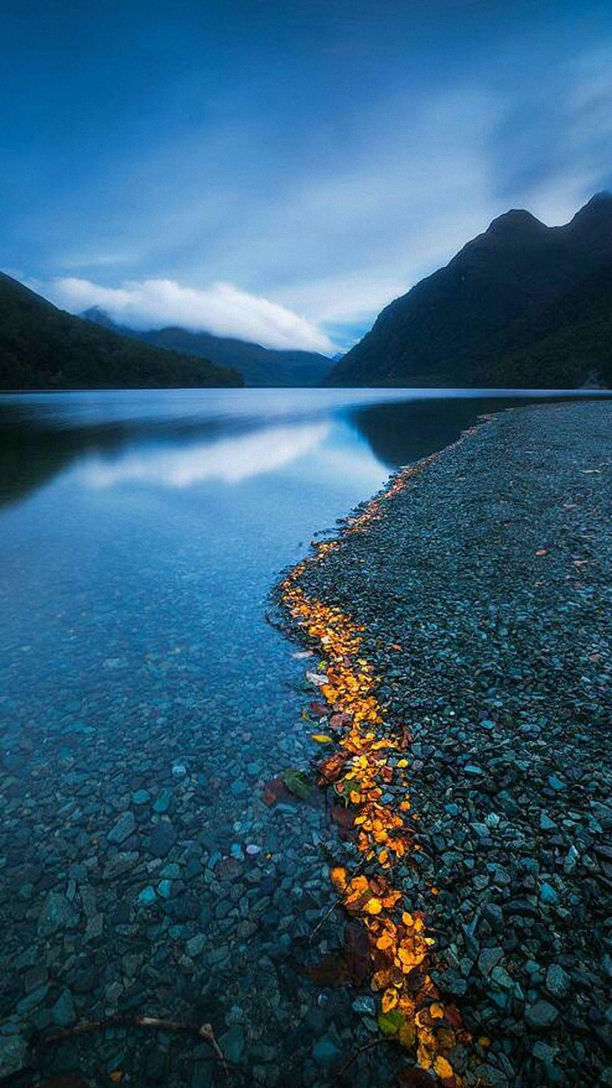 Serene Mountain Lake at Dusk with Golden Leaves on a Pebble Shore HD phone wallpaper