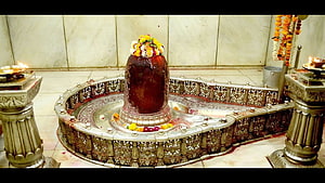 Sacred Shiva Lingam in Ornate Silver Temple Shrine with Flower Offerings HD wallpaper