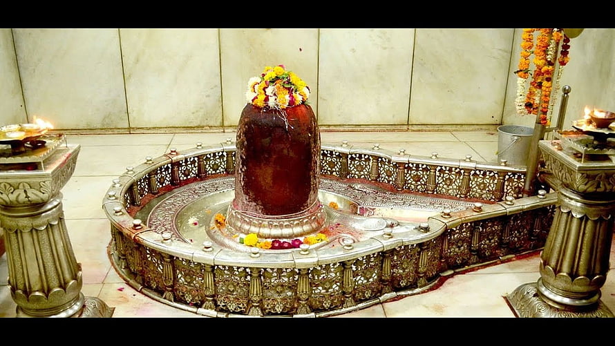 Sacred Shiva Lingam in Ornate Silver Temple Shrine with Flower Offerings HD wallpaper