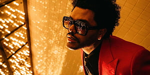 The Weeknd in a red suit and sunglasses with golden bokeh lights HD wallpaper