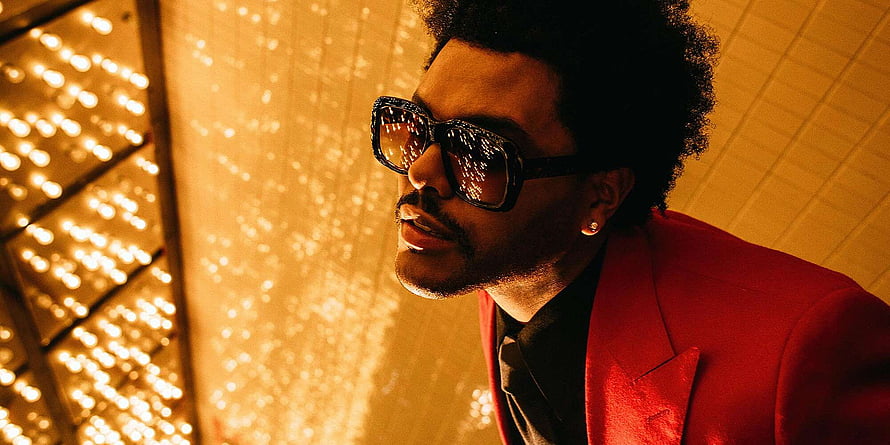 The Weeknd in a red suit and sunglasses with golden bokeh lights HD wallpaper
