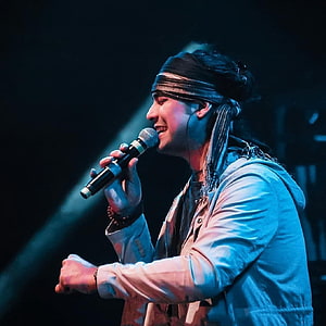 Jubin Nautiyal performing live on stage with microphone under blue spotlight HD phone wallpaper