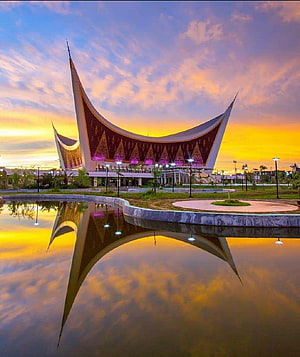 Grand Mosque of West Sumatra in Padang City, Indonesia at Sunset with Water Reflection HD phone wallpaper