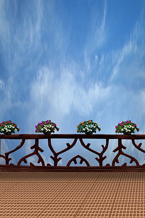 Ornate Balcony Railing with Colorful Flower Boxes Against a Bright Blue Sky HD phone wallpaper