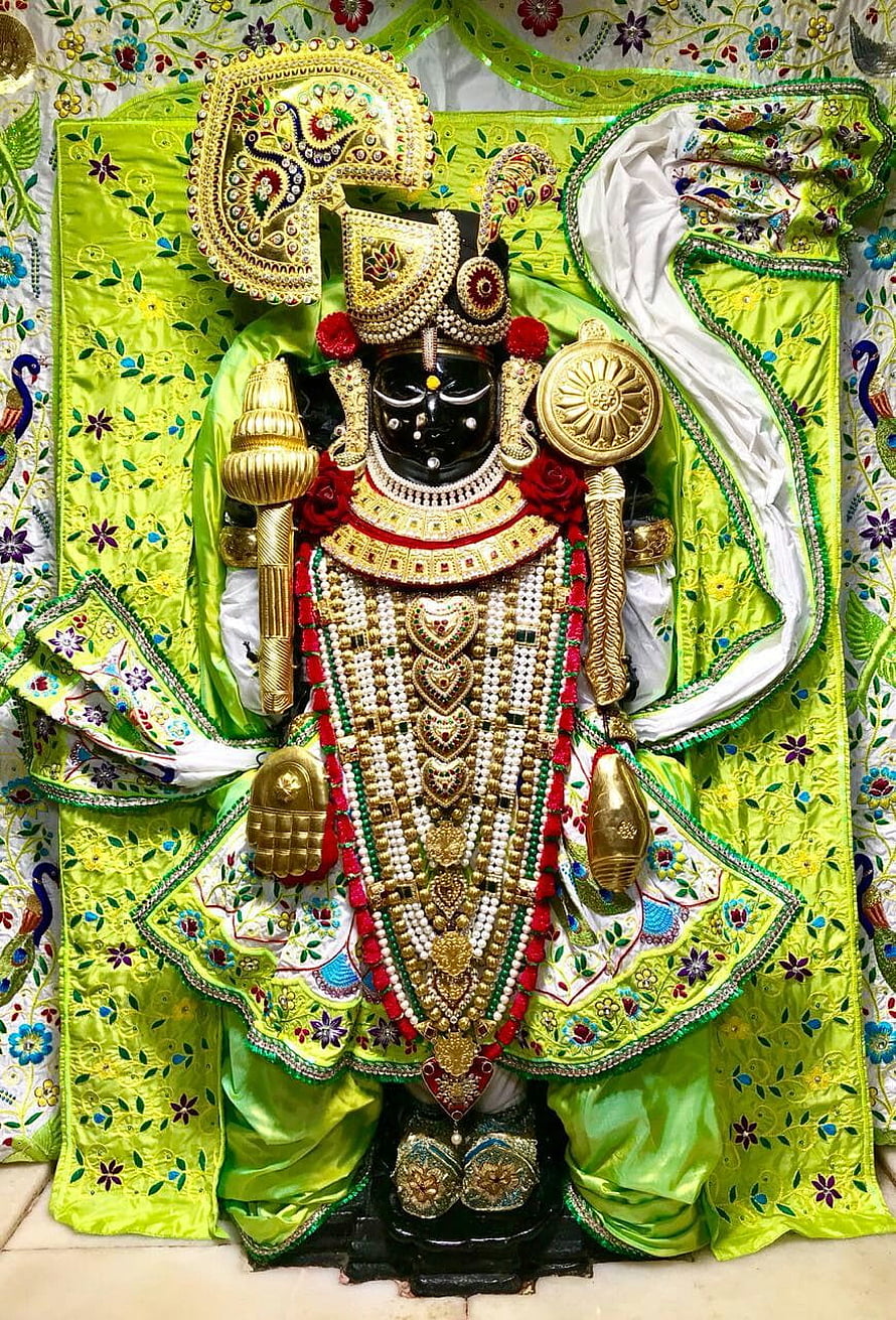 Lord Jagannath adorned in vibrant green silk garments and intricate gold jewelry HD phone wallpaper