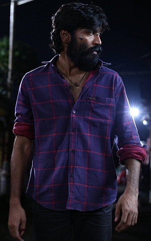 Dhanush in a purple plaid shirt with a full beard and facial scar in a dramatic night scene HD phone wallpaper