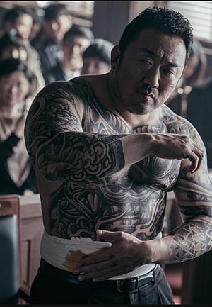 Ma Dong-seok shirtless with full body tattoos and bandaged waist in gritty movie scene HD phone wallpaper