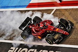 Ferrari F1 Car Performing Burnout with Tire Smoke on Race Track HD wallpaper
