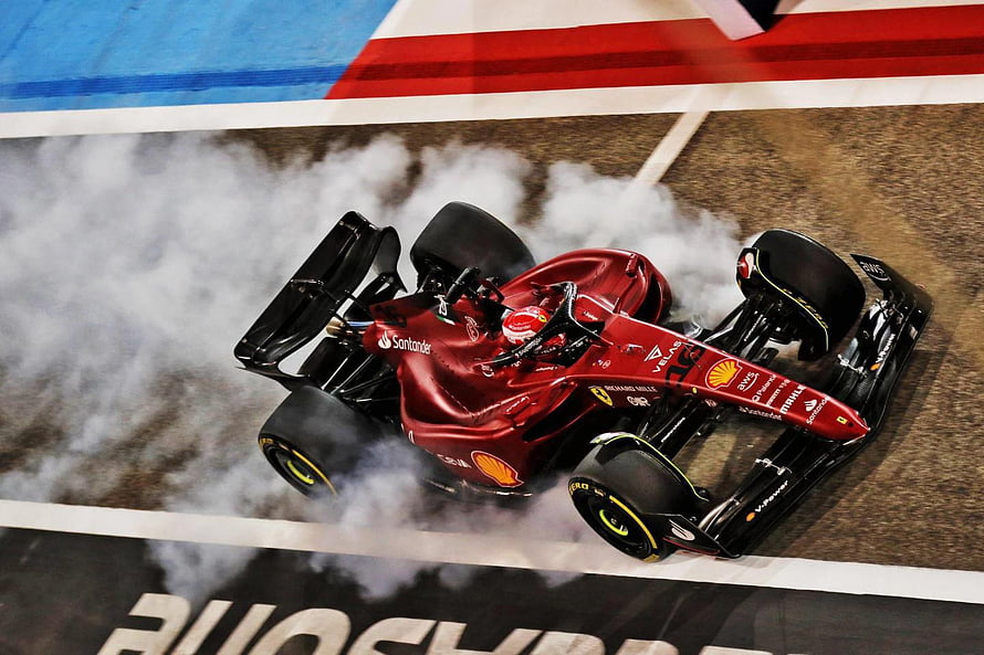 Ferrari F1 Car Performing Burnout with Tire Smoke on Race Track HD wallpaper