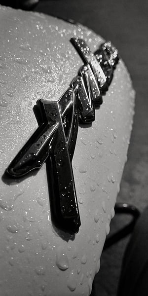Close-up of a wet Yamaha motorcycle emblem in black and white HD phone wallpaper