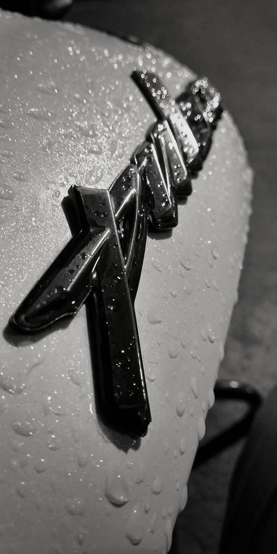 Close-up of a wet Yamaha motorcycle emblem in black and white HD phone wallpaper