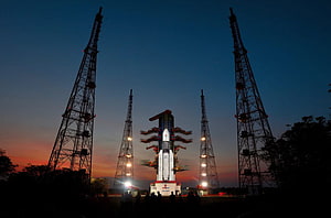 ISRO GSLV rocket on launch pad at dusk with service towers and twilight sky HD wallpaper