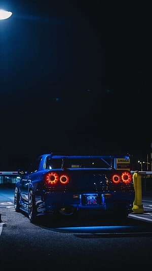 Nissan Skyline GT-R R34 Rear View at Night with Glowing Taillights and Blue Underglow HD phone wallpaper