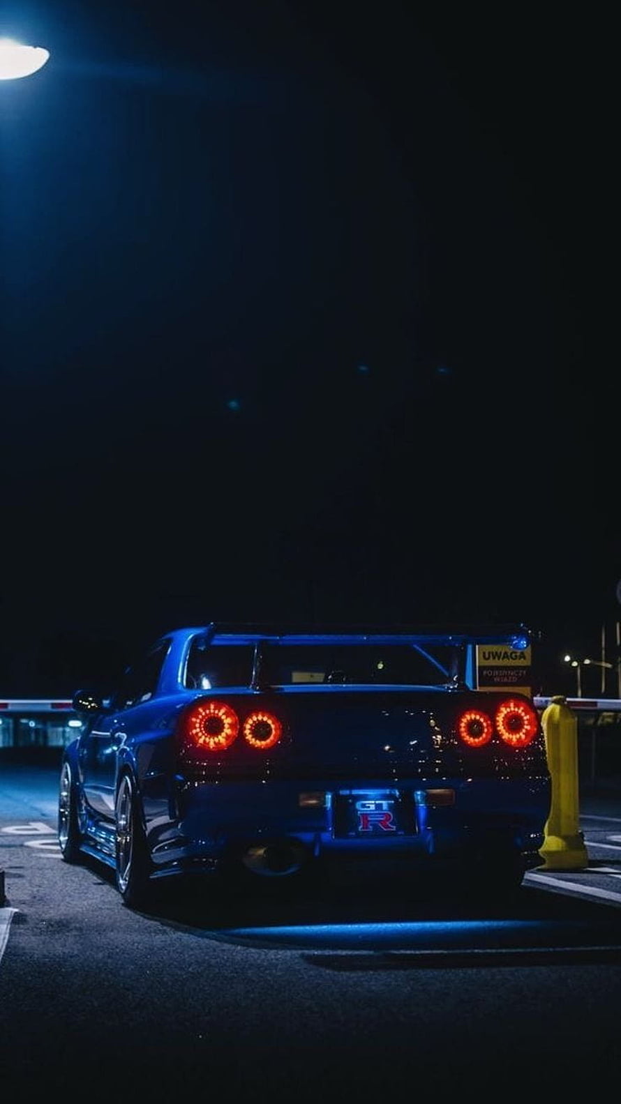 Nissan Skyline GT-R R34 Rear View at Night with Glowing Taillights and Blue Underglow HD phone wallpaper