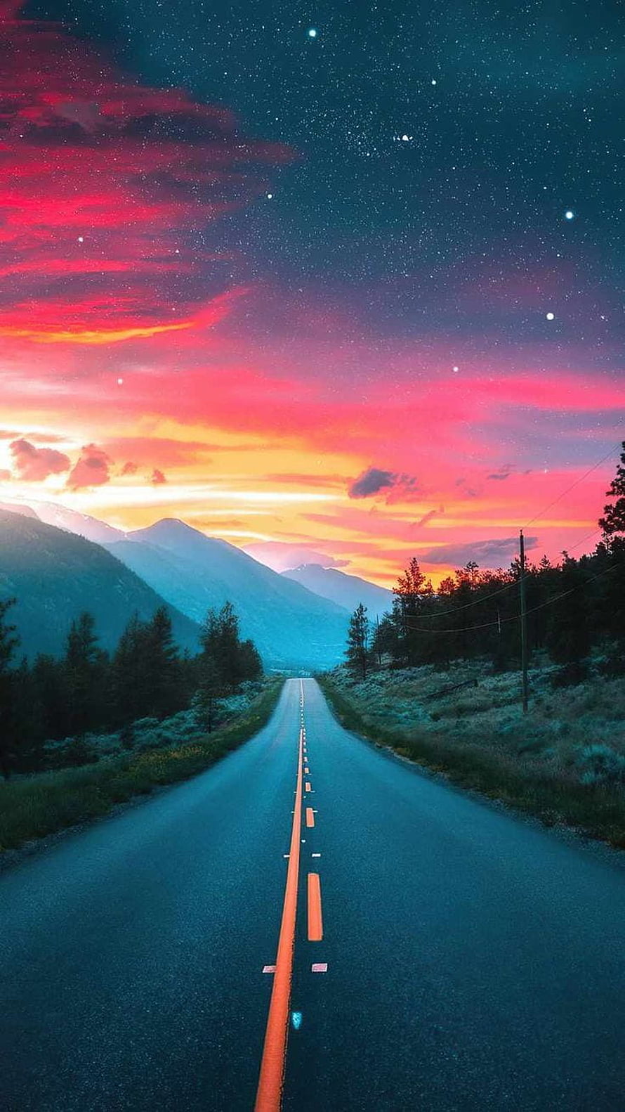Endless Highway Stretching Toward Majestic Mountains Under a Vibrant Sunset and Starry Sky HD phone wallpaper