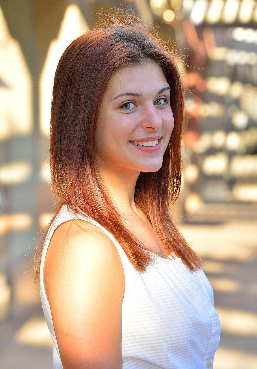 Leah Gotti smiling portrait in a white sleeveless top with warm golden hour lighting HD phone wallpaper