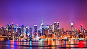 New York City Skyline at Night with Vibrant Purple Sky and Water Reflections HD wallpaper