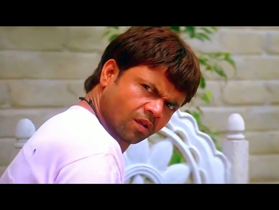 Rajpal Yadav Intense Expression in White Shirt Against Stone Wall HD wallpaper