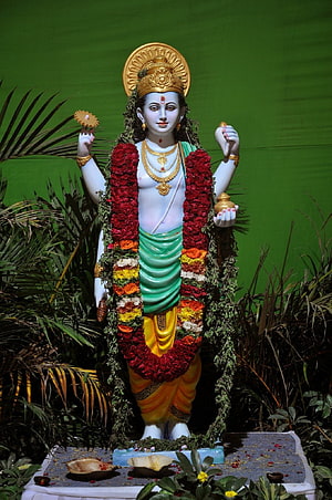 Dhanvantari Hindu Deity Statue Adorned With Flower Garlands And Golden Crown HD phone wallpaper