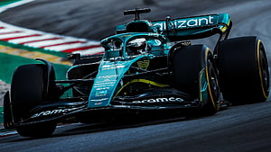 Aston Martin Formula 1 race car speeding on a wet track with Aramco livery HD wallpaper
