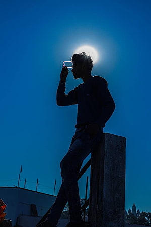 Silhouette of a man holding a phone against the bright sun on a rooftop, 15 Sad Boy For Whatsapp DP, whatsapp dp boys HD phone wallpaper