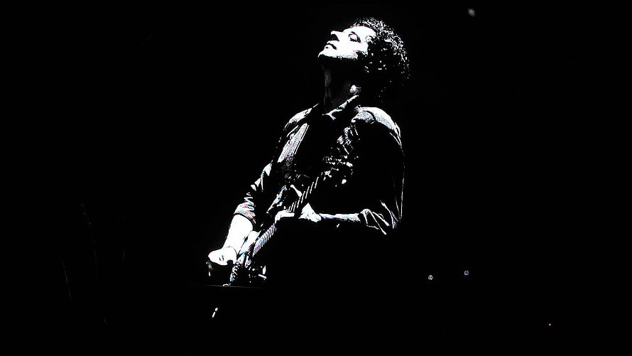 Bono U2 Performing Live On Stage With Guitar In Dramatic Spotlight HD wallpaper