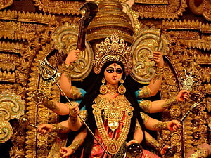 Ornate Durga Puja idol adorned in gold jewelry and traditional red attire HD wallpaper