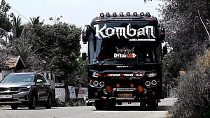Komban Movie Black Tour Bus With Dawood Sticker Driving On Road HD wallpaper