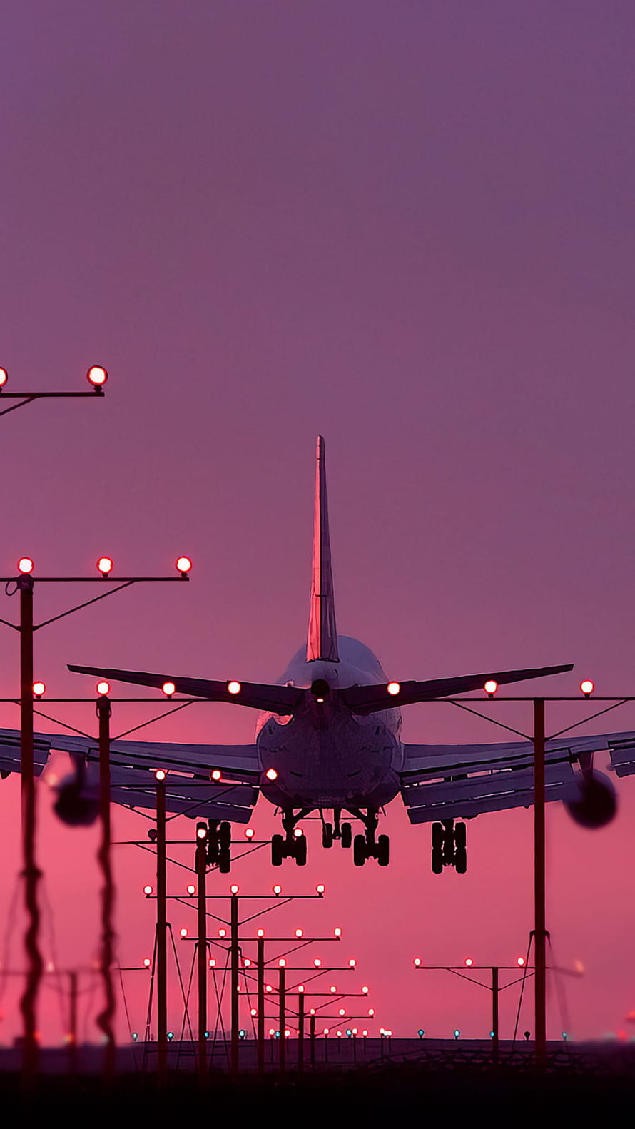 Airplane Landing on Runway at Sunset with Purple Sky and Red Lights HD phone wallpaper