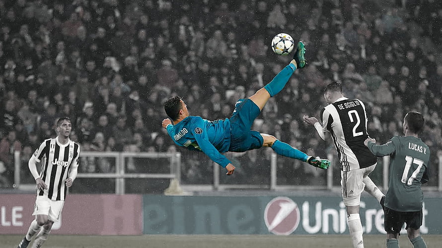 Cristiano Ronaldo performing a spectacular bicycle kick in a teal Real Madrid jersey during a Champions League match against Juventus HD wallpaper