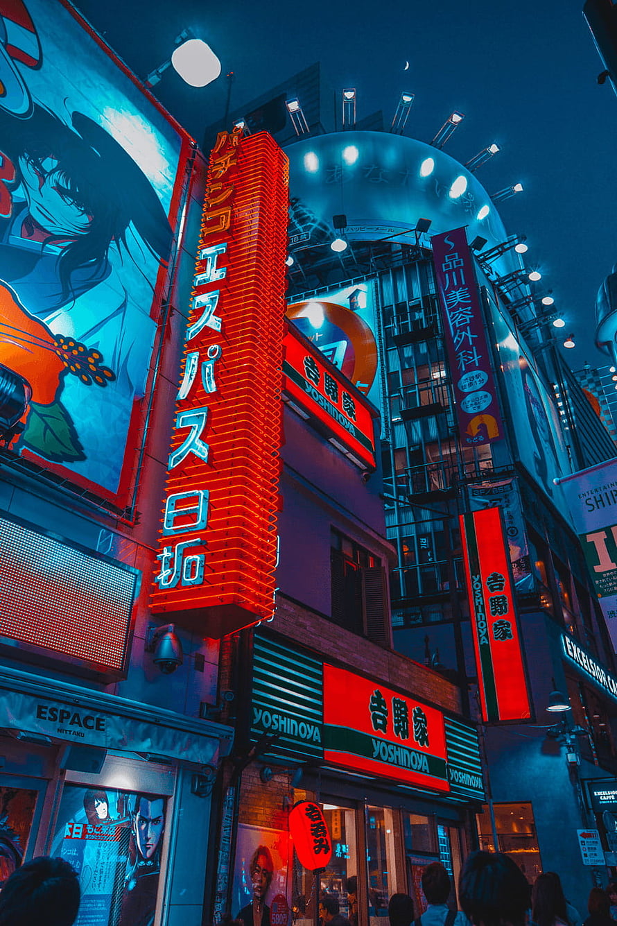 Neon-lit Tokyo street scene at night featuring Yoshinoya restaurant and vibrant anime billboards HD phone wallpaper