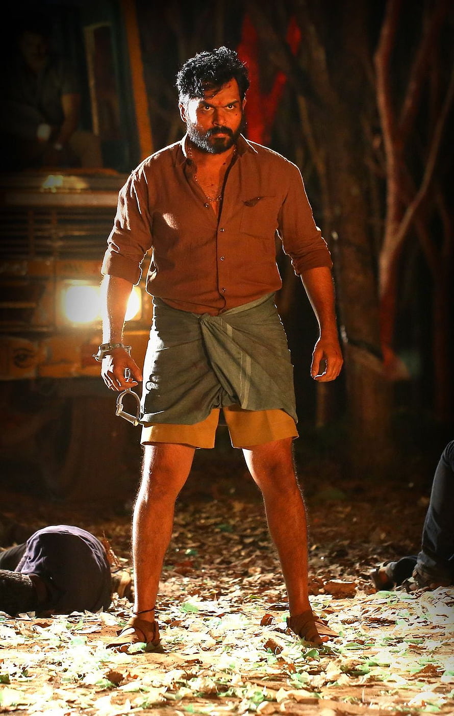 Dhanush in intense action scene from the movie Vikram wearing brown shirt and lungi at night HD phone wallpaper