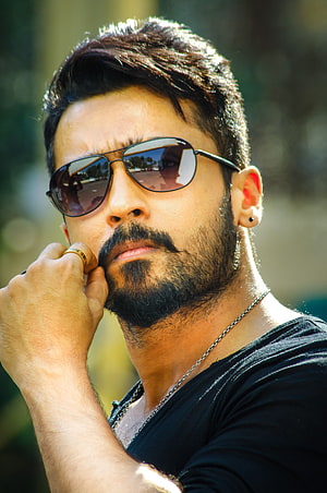 Suriya in aviator sunglasses and black t-shirt with beard and gold ring HD phone wallpaper