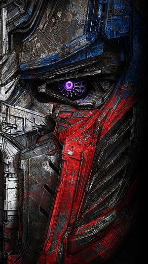 Close-up of Optimus Prime's face with glowing purple eye and battle-damaged armor HD phone wallpaper