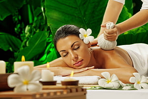 Relaxing Spa Massage Scene With Herbal Compress, Candles, and Tropical Flowers HD wallpaper