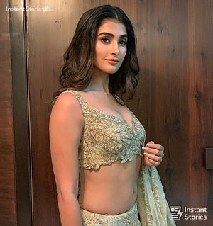 Pooja Hegde in a stunning gold embroidered lehenga choli posing against a wooden background HD phone wallpaper