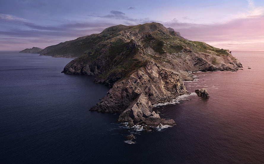 Aerial View of Rugged Coastal Island at Dusk with Dramatic Rocky Cliffs and Calm Ocean Waters HD wallpaper