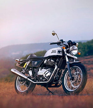 Royal Enfield Classic 350 motorcycle parked in a scenic field at sunset HD phone wallpaper