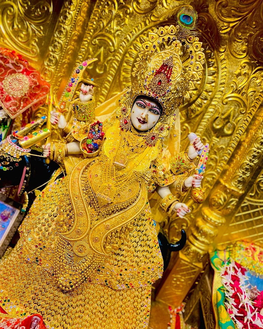 Ornate Golden Maa Malataj Deity Idol with Intricate Jewelry and Temple Backdrop HD phone wallpaper