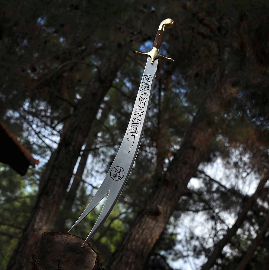 Zulfikar Sword with Arabic Calligraphy Engraved on Blade Set Against Forest Background HD phone wallpaper
