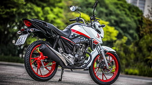 White and Red Honda Titan S 160 Motorcycle Parked on a Road with Green Foliage HD wallpaper