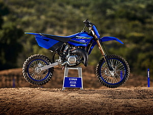 Blue Yamaha YZ250 dirt bike on a dirt track with forest background HD wallpaper
