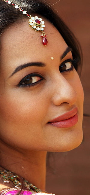 Close-up portrait of a woman wearing traditional Indian bridal jewelry and a maang tikka, Celebrity/Sonakshi Sinha, indian actress face close up HD phone wallpaper