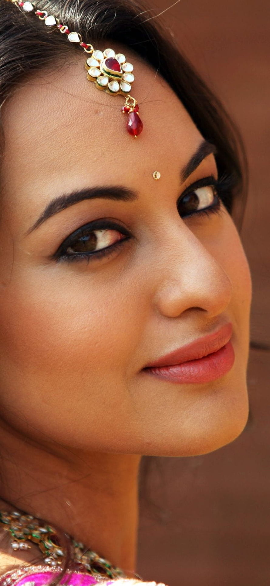 Close-up portrait of a woman wearing traditional Indian bridal jewelry and a maang tikka, Celebrity/Sonakshi Sinha, indian actress face close up HD phone wallpaper